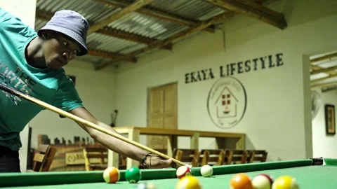Handheld shot of a young man attempting a jump shot on a pool table Stock Footage 254793159