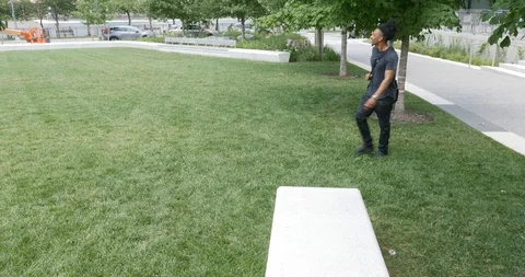 Handheld shot of young man with backpack laying down on grass Stock Footage 120147200