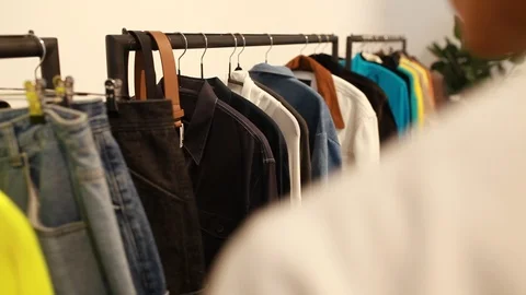 Handheld shot of a young man browsing clothing in a store Stock-Footage 114886059