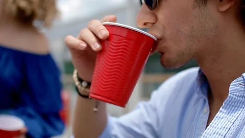 Handheld shot of a young man drinking alcohol with his friend Stock Footage 114880459