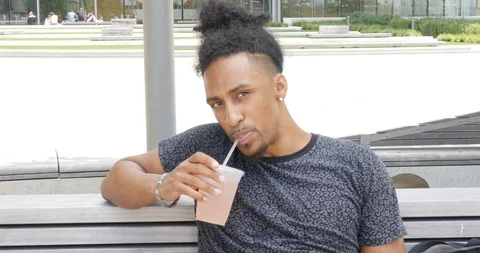 Handheld shot of young man drinking juice from disposable cup Stock Footage 120147642