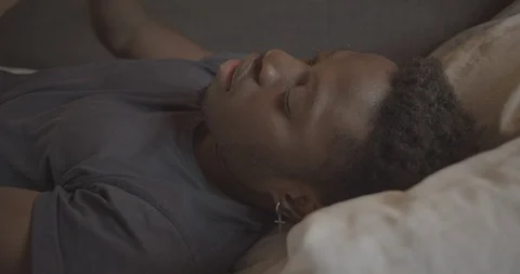Handheld shot of young man lying on bed Stock Footage 120421601