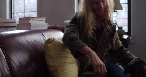 Handheld shot of young man playing with his dog on sofa Stock Footage 114841505