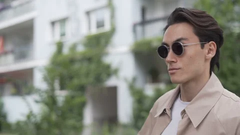 Handheld shot of young man posing for camera in sunglasses Stock Footage 114875883