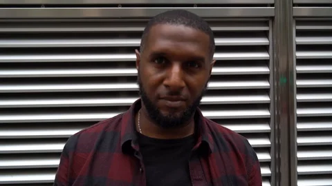 Handheld shot of a young man posing and smiling in front of the camera Stock Footage 114880908