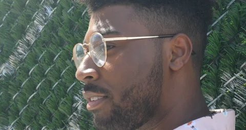 Handheld shot of young man posing against fence Stock Footage 120153733