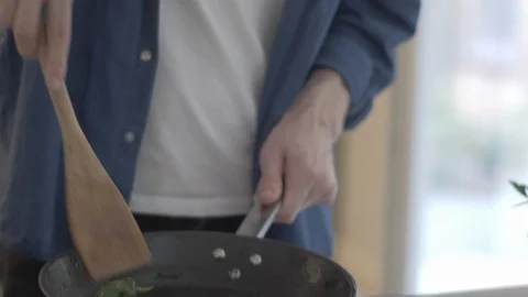 Handheld shot of young man serving sauteed green chillies 스톡 동영상 114842316
