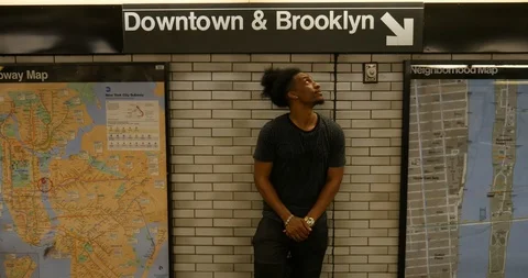 Handheld shot of young man standing against wall in subway Stock Footage 120149877