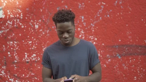 Handheld shot of young man standing using smartphone Stock Footage 120420526