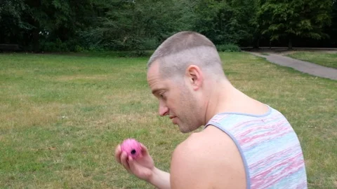 Handheld shot of young man throwing ball for dog in park Vídeo Stock 120427196