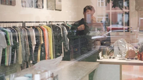 Handheld shot of young man trying on a jacket clothing shop Stock Footage 114875557