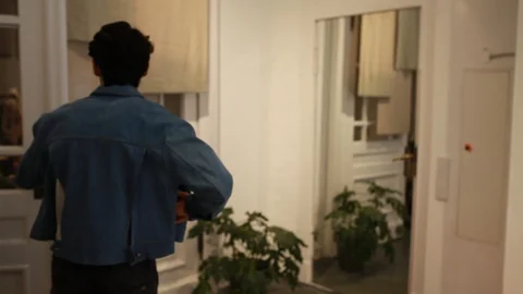 Handheld shot of a young man trying jacket in a store Stock Footage 114886062
