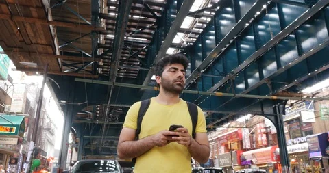 Handheld shot of young man using his smart phone while standing Stock Footage 120069046