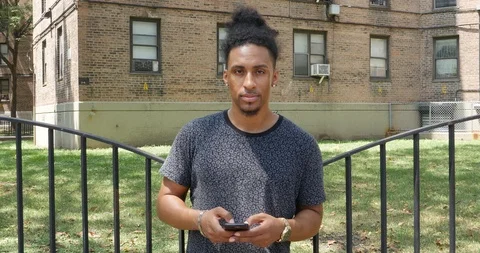 Handheld shot of young man using his smart phone while standing Stock Footage 120069113