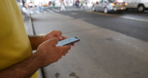 Handheld shot of young man using smart phone on sidewalk Stock Footage 120149116