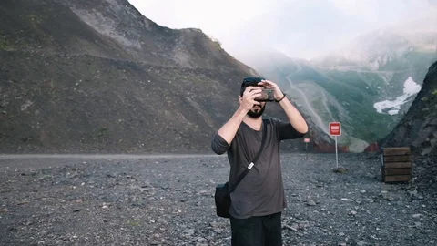 Handheld shot of young man using smart phone while standing on land Stock Footage 122519983