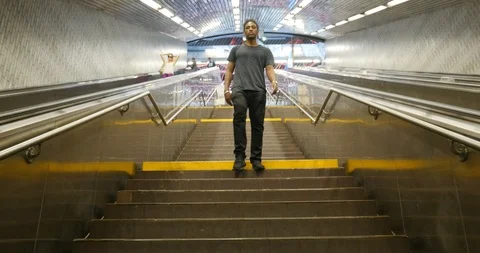 Handheld shot of young man walking down stairs Stock Footage 120150202