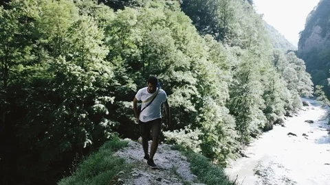 Handheld shot of young man walking on rock in forest Stock Footage 122519974