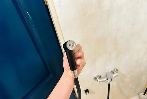 Handheld showerhead in a modern bathroom. Stock Photos