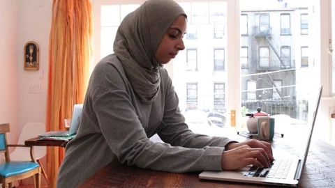 Handheld side view shot of young female freelancer blogging through laptop Stock Footage 114860102