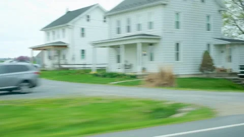 Handheld Side Window Perspective of Passing Farmland Silos and Rural Houses Stock Footage 332684707