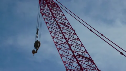 Handheld slow motion 120 fps drive by of crane with blue sky Stock Footage 233502783