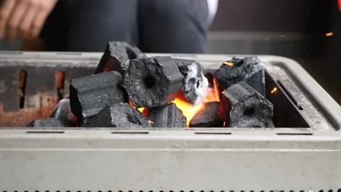Handheld slow motion of charcoal being lit on fire with sparks flying Stock Footage 155776014
