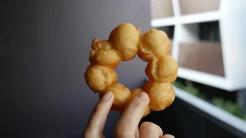 Handheld slow motion push towards hand holding pon de ring mochi donut Stock Footage 155776012