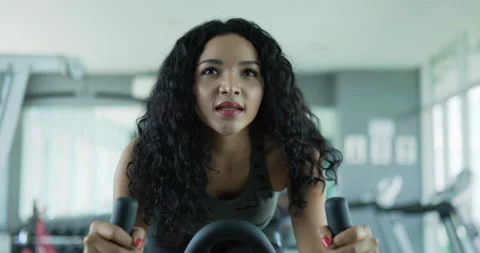 Handheld slow motion shot, Front view Asian young female spinning bike machchine 스톡 동영상 225004552