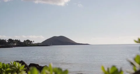 Handheld slow motion shot of the ocean with an Island in the distance Stock Footage 134362073