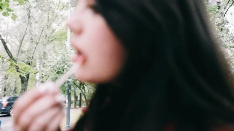 Handheld slow motion shot of a young woman applying lipstick Stock Footage 122517576