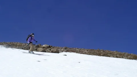 Handheld Slow Motion of skier in blue suit sliding down on snowy hill, Iceland Stock Footage 124228275