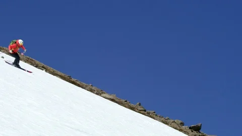 Handheld Slow Motion of skier in red suit skiing on snowy hill, Iceland Stock Footage 124228377