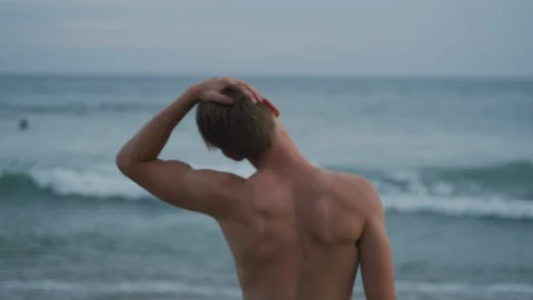 Handheld slow motion of surfer warming up and getting ready for surfing in sea Stock Footage 120292510