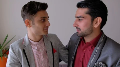 Handheld stabilized shot of two male friends wearing gray suits chatting and exc Stock Footage 101290605