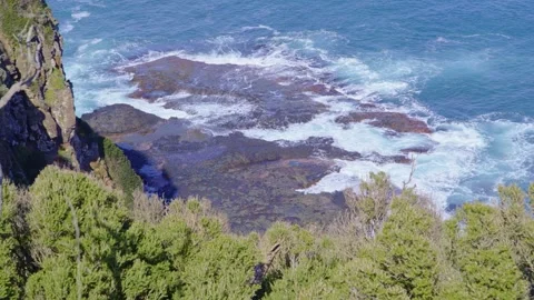 Handheld Static: Ocean Waves Crashing on Rocks Below Coastal Cliff Stock Footage 317235896