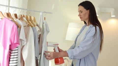 Handheld steamer for ironing clothes at home Stock Footage 345680445