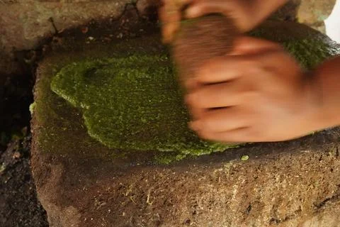 Hand‑held stone grinder: robust mortar and pestle, textured bowl crushes spices, Stock Photos