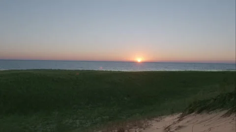 Handheld sunset behind grassy dunes Vidéo 48866620
