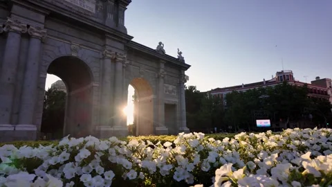 Handheld Sunset Shot of Puerta de Alcalá in Madrid With Blooming Flowers in Stock Footage 341894778