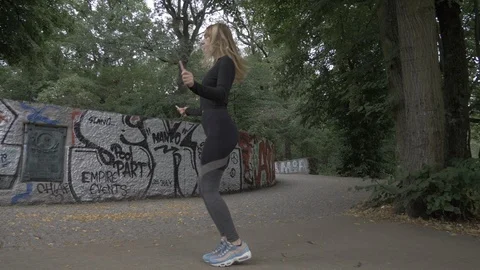 Handheld tilt down shot of young woman skipping rope Stock-Footage 114843419