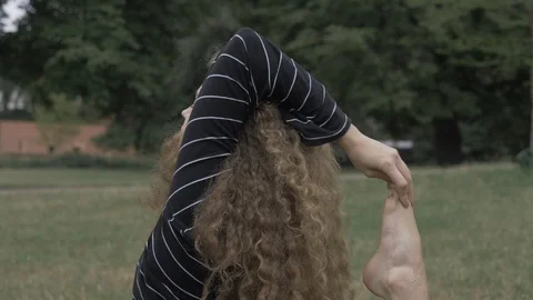 Handheld tilt down shot of young woman stretching and doing yoga Video stock 114843543