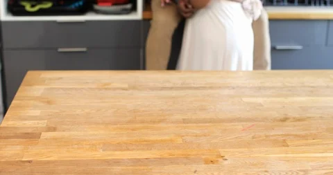 Handheld tilt up shot of affectionate mid adult couple laughing in kitchen Stock Footage 119798194