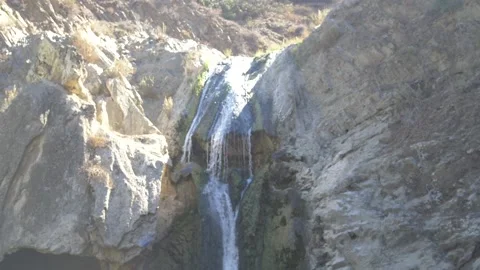 Handheld Tilt Shot of a Waterfall with Sun Flares Stock Footage 217493853