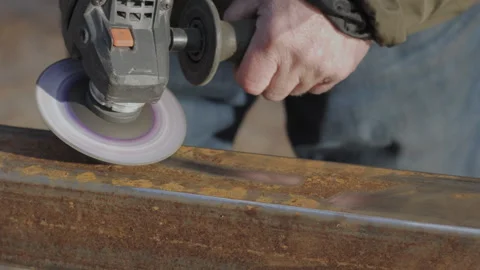 Handheld tool polishing metal surface in outdoor workshop during daytime Stock Footage 313517013
