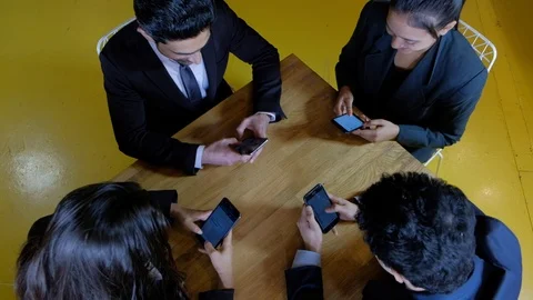 Handheld top angle shot of four colleagues on a cafe table occupied with their s Stock Footage 104530676