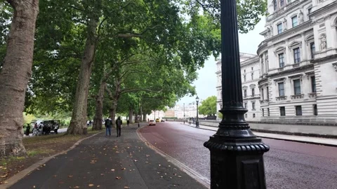 Handheld tracking shot along The Mall by Admiralty Arch with rainy roadway Stock Footage 346678245