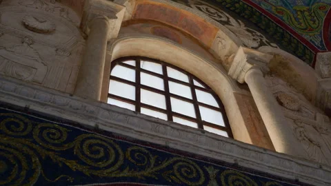 Handheld Upward Pan of Baptistery Window with Saint Reliefs Stock Footage 320135794