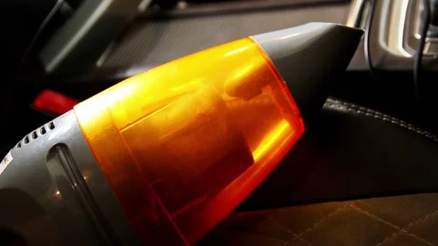 Handheld vacuum cleaner with bright orange transparent dustbin showing collected Stock Footage 325296356