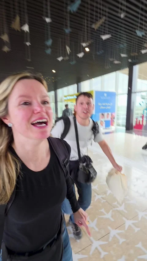 Handheld vertical shot of a couple running late at the airport Vídeo Stock 333834863